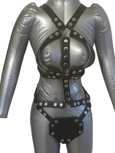 Women's leather harness outlining the breasts with a dildo harness attached.