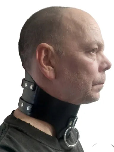 Person wearing a black leather wide collar around his neck.