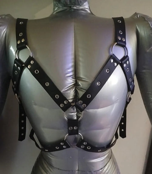 Black leather harness with metal rings on a mannequin against a neutral background