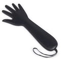 A black leather paddle with a strap, designed for adult use.